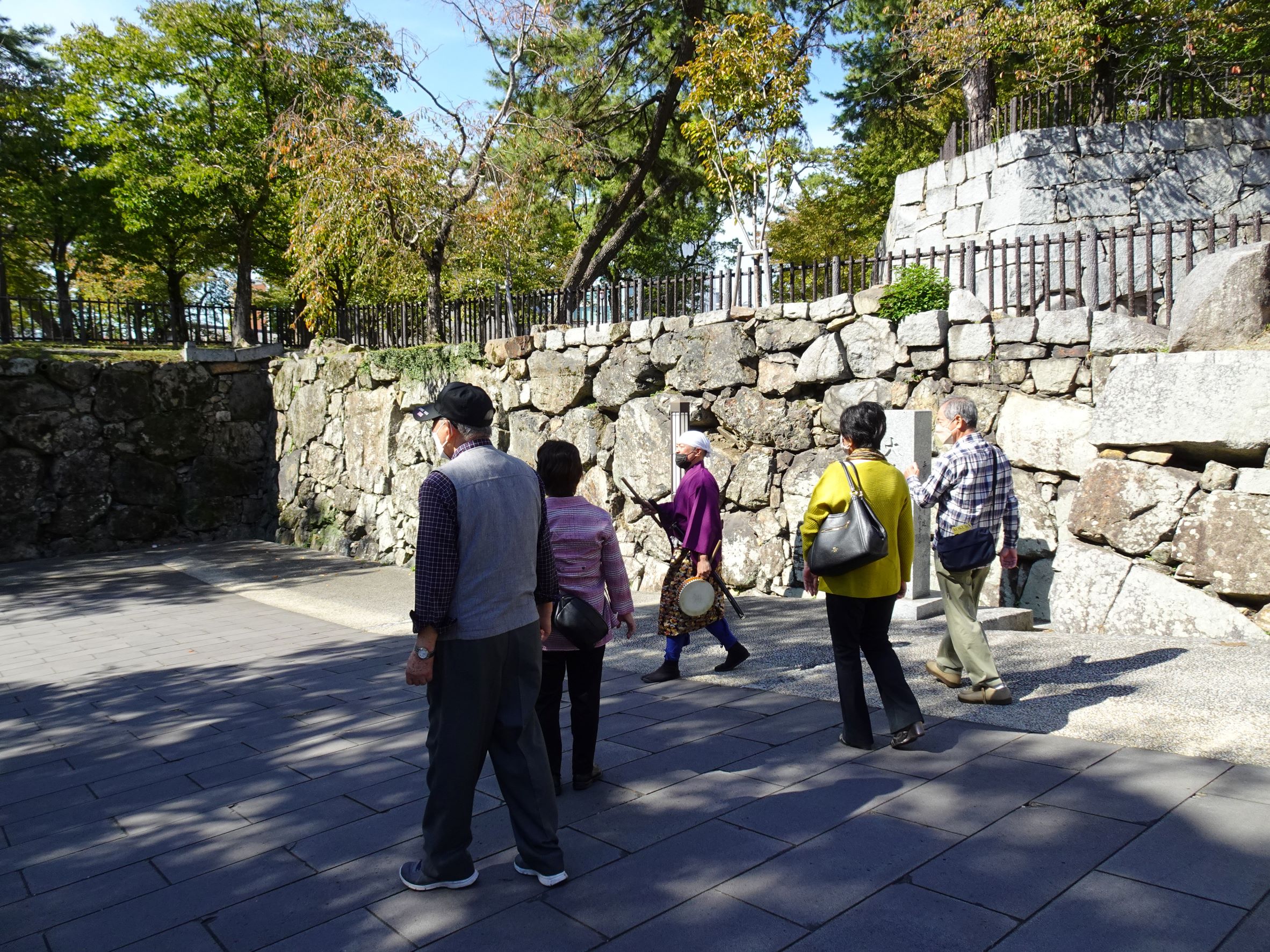 小倉城の石垣についての説明を受けている様子。